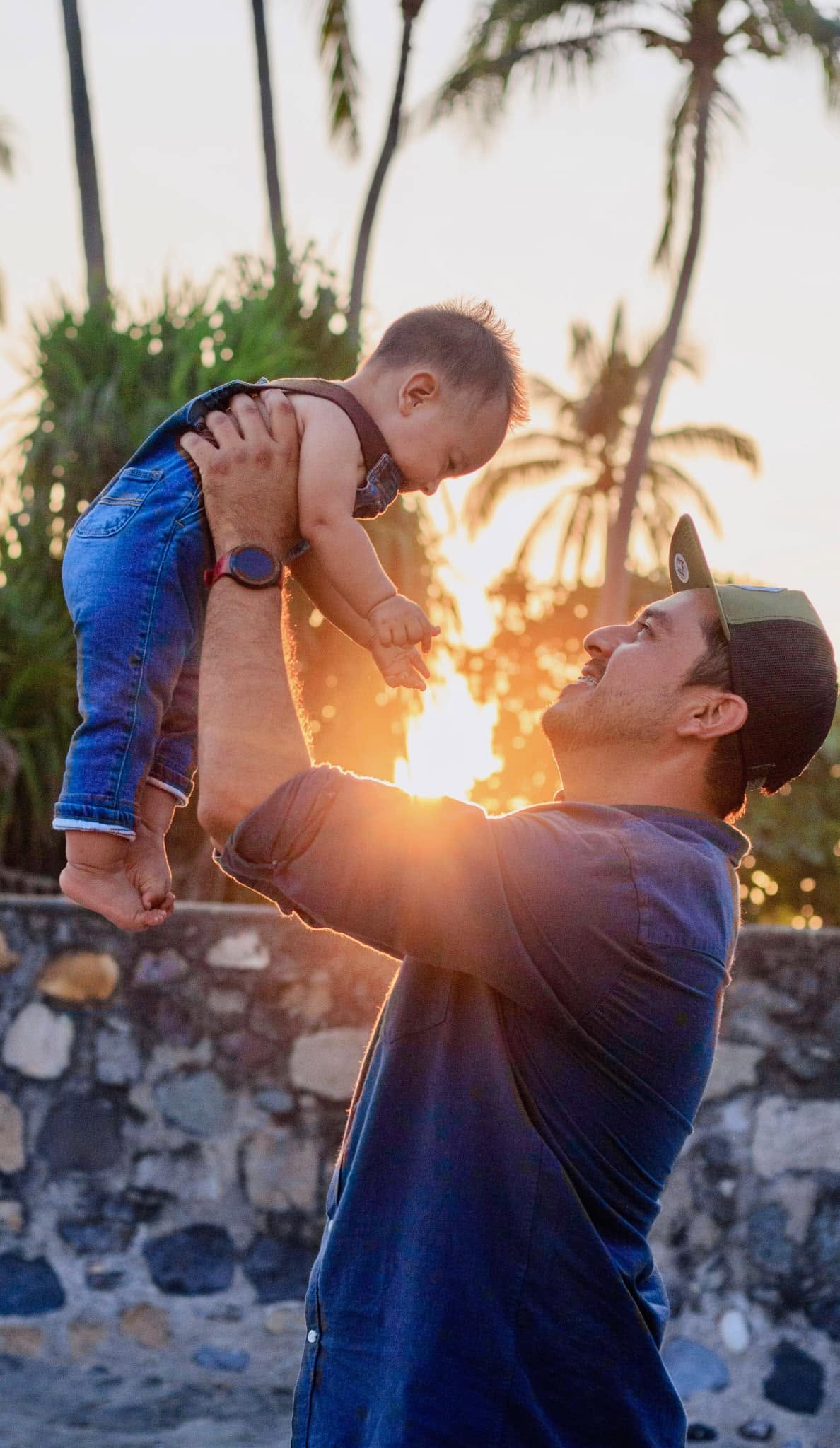 Padre levantando a su hijo al atardecer