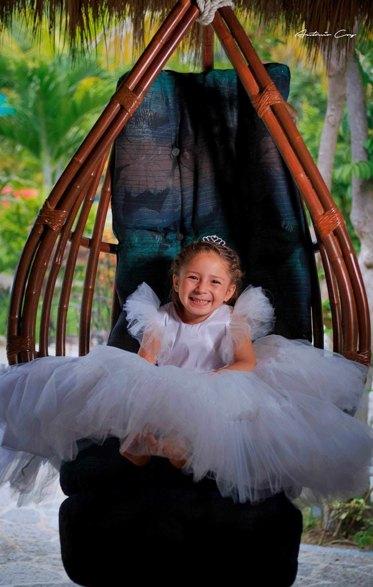 Niña con vestido blanco en un columpio