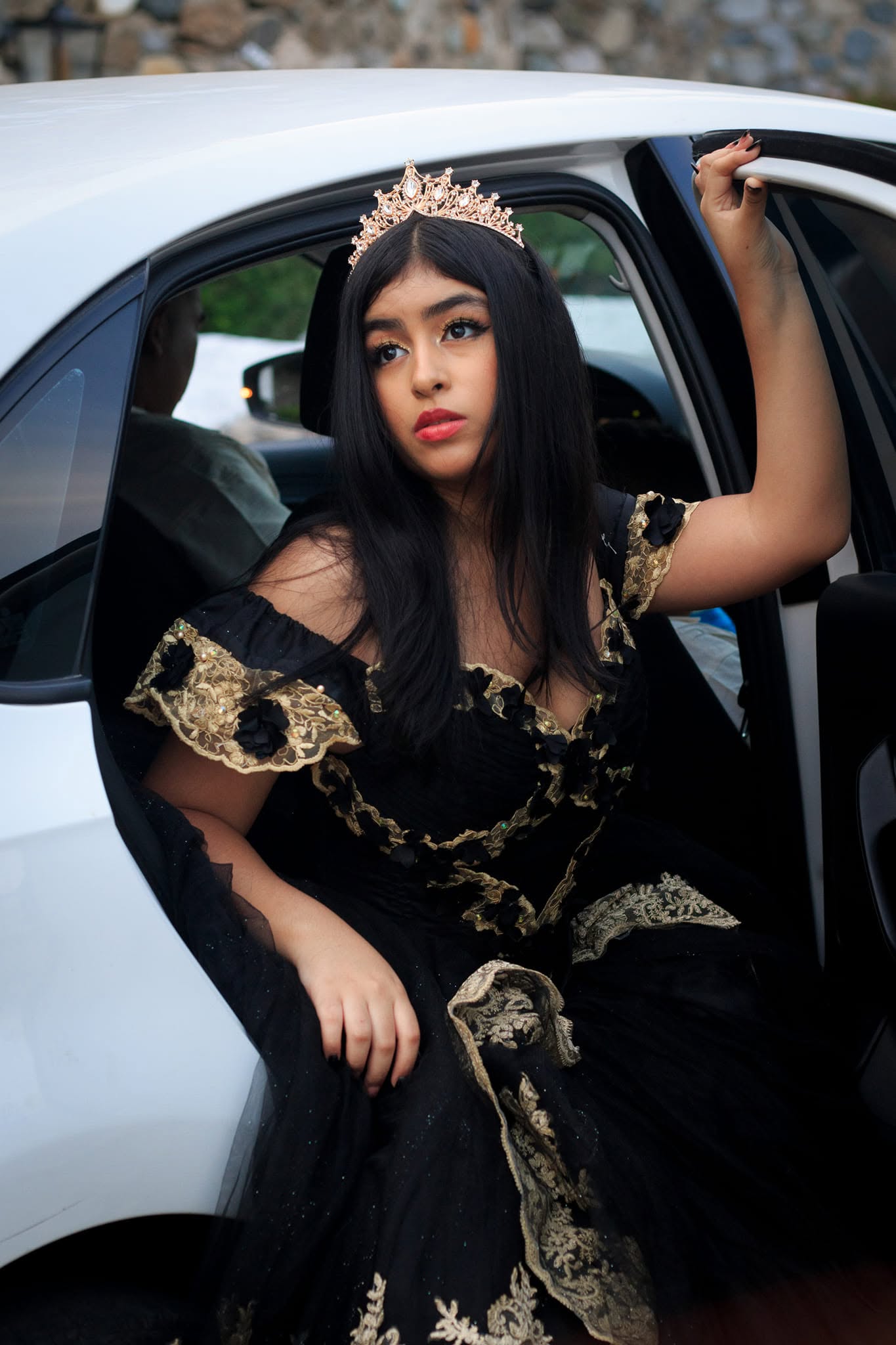 Quinceañera saliendo de un auto blanco